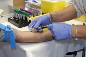 Medical Assistant working in hospital drawing blood from patient